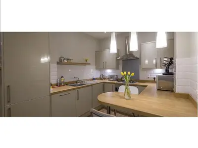 a kitchen with a vase of flowers on a table at The Lane Apartment in Edinburgh