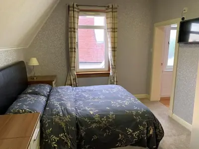 a small bedroom with a bed and a window at Hillhouse in Edinburgh