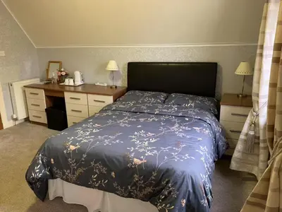 a bedroom with a bed with a blue comforter at Hillhouse in Edinburgh