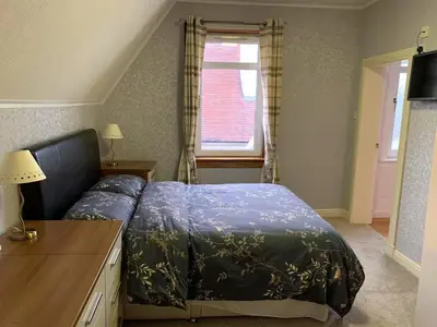 a bedroom with a bed and a window at Hillhouse in Edinburgh