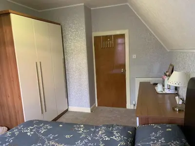 a bedroom with a bed and a desk and a door at Hillhouse in Edinburgh