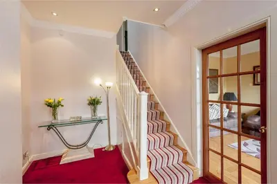 a staircase in a home with a red carpet at Hillhouse in Edinburgh
