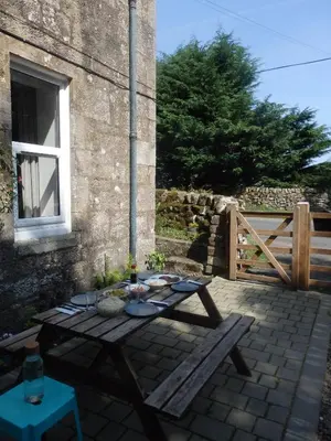 a picnic table in front of a building at Lovely house next to Euchan River in Sanquhar