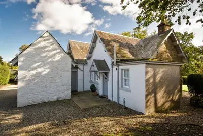 a white house with a roof at Cardross Holiday Cottages in Arnprior