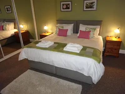 a bedroom with a large bed with pink pillows at The Garden Flat in Crieff