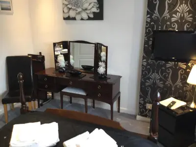 a bedroom with a desk with a mirror and a tv at Three Bridges Bed & Breakfast in Rosyth