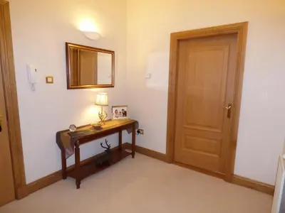 a room with a table with a lamp and a door at The Pipers No 7 Lomond Castle in Balloch