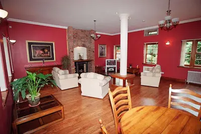 a living room with red walls and white furniture at Coachouse in Balloch