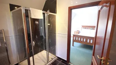 a shower with a glass door in a bathroom at Coachouse in Balloch