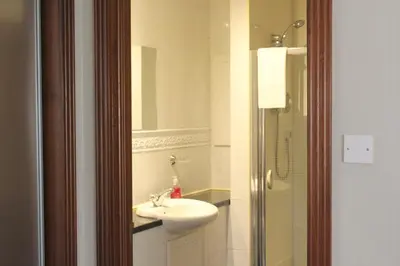 a bathroom with a sink and a mirror at Stables Lodge in Balloch