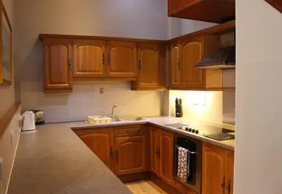 a kitchen with wooden cabinets and a counter top at Stables Lodge in Balloch