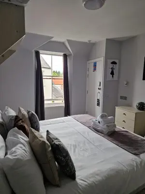 a large white bed in a room with a window at Black Bull Inn, Moffat in Moffat