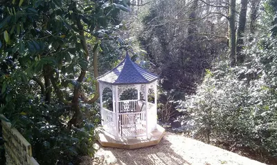 a gazebo with a blue roof on a path at Smiddy Lodge in Balloch
