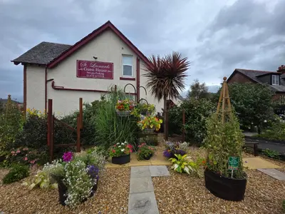 a garden with plants in front of a house at St Leonards Guest House in Largs