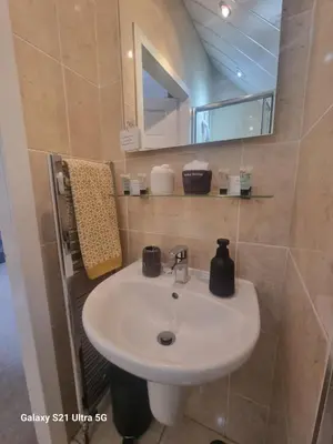a bathroom with a white sink and a mirror at St Leonards Guest House in Largs