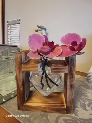 a glass vase with flowers in it on a table at St Leonards Guest House in Largs
