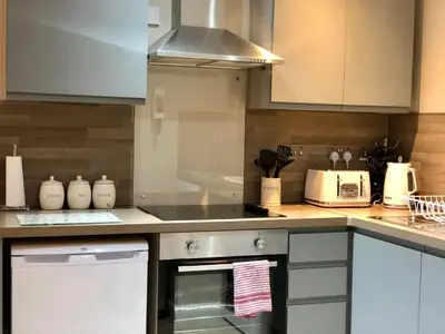 a kitchen with white cabinets and a stove top oven at Hunters Lodge Apartments in Ballachulish