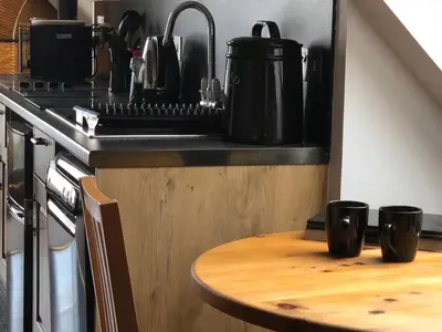 a kitchen with a table with two cups on a counter at Hunters Lodge Apartments in Ballachulish