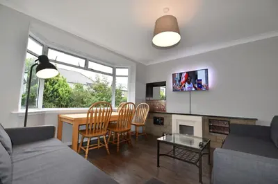 a living room with a couch and a table and chairs at Sighthill 3 Bedrooms with Private Garden in Edinburgh
