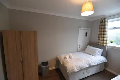 a small bedroom with a bed and a window at Sighthill 3 Bedrooms with Private Garden in Edinburgh
