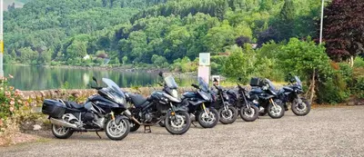 a row of motorcycles parked next to a body of water at The Four Seasons Hotel in Saint Fillans