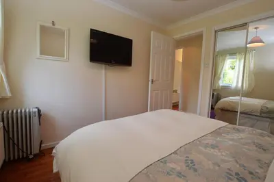 a bedroom with a bed and a television on the wall at Amber Lodge in Hunters Quay