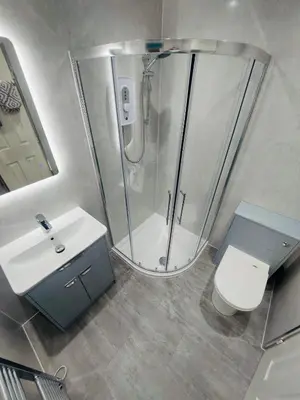 a bathroom with a shower and a toilet and a sink at Amber Lodge in Hunters Quay
