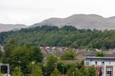a town with houses and mountains in the background at Lomond Serviced Apartments- Inglewood in Alloa