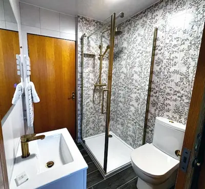 a bathroom with a shower and a toilet and a sink at Stob Binnein Cottage in Crianlarich