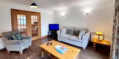 a living room with a couch and a table at Stob Binnein Cottage in Crianlarich