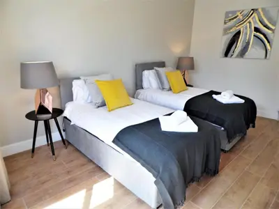 two beds with yellow and white pillows in a room at Signature - Langlands House in Glasgow
