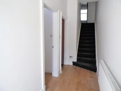 a hallway with white walls and a stair case at Signature - Langlands House in Glasgow
