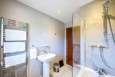 a bathroom with a sink and a shower at Gamekeeper Lodge loch and mountain view free wifi in Crianlarich