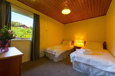 a room with two beds and a window with a window at Kestrel Lodge with mountain view free wifi in Crianlarich