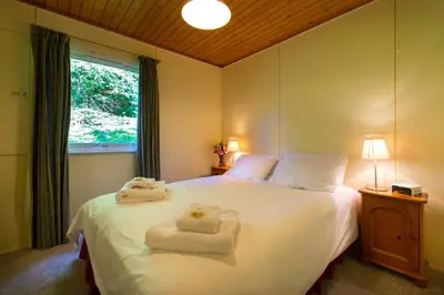 a bedroom with a white bed with towels on it at Kestrel Lodge with mountain view free wifi in Crianlarich