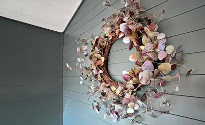 a wreath of dried flowers on a wall at Lapwing Lodge with loch and mountain view in Crianlarich