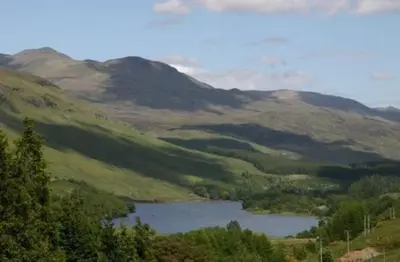 a view of a valley with a lake and mountains at Osprey Lodge with river and mountain view in Crianlarich