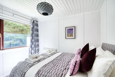 a bedroom with a large bed and a window at Otter with mountain view and enclosed decking in Crianlarich