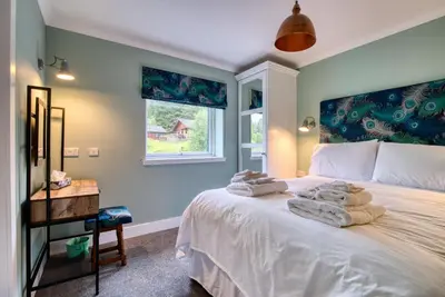 a bedroom with a bed with towels on it at Stunning 5 star lodge with loch and mountain views in Crianlarich