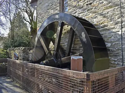 a large metal wheel in a brick wall at Can Duran in Killin