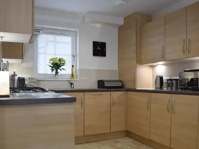 a kitchen with wooden cabinets and a window at Can Duran in Killin