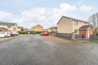 a red car parked in the driveway of a house at Prime Commuter Executive Apartment Dunfermline in Dunfermline
