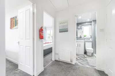 a white bathroom with a toilet and a sink at Prime Commuter Executive Apartment Dunfermline in Dunfermline