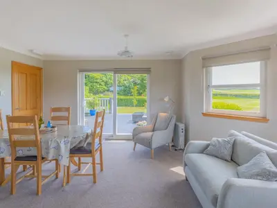 a living room with a table and a couch at The Potting Shed in Challoch