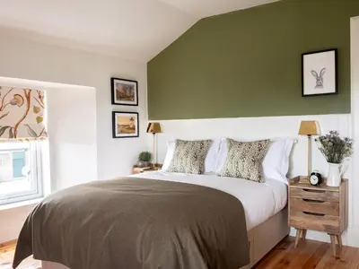 a bedroom with a bed with a green wall at High Ranachan in Campbeltown