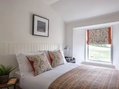a bedroom with a white bed and a window at High Ranachan in Campbeltown