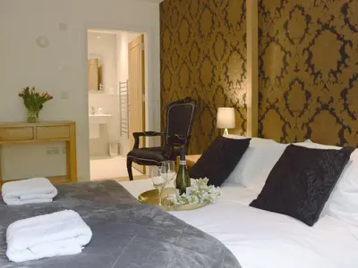 a bed with a plate of flowers and wine glasses at Anemone in Kenmore