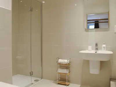 a bathroom with a shower and a sink at Anemone in Kenmore