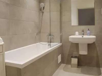 a bathroom with a shower and a sink and a bath tub at Anemone in Kenmore