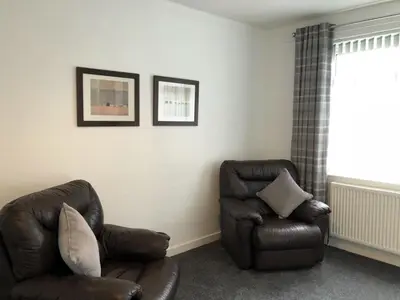 a living room with a couch and a chair at Signature - Anderson View in Motherwell